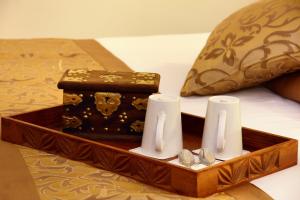 a wooden tray with candles and a box on a bed at Sea Cliff Resort & Spa in Zanzibar City