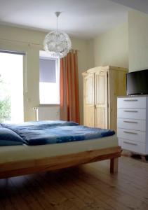 - une chambre avec un lit, une télévision et un lustre dans l'établissement Ferienwohnung Gessert, à Querfurt