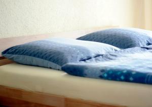 two blue pillows sitting on top of a bed at Ferienwohnung Gessert in Querfurt