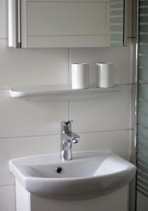 a white sink in a bathroom with a mirror at Ferienwohnung Gessert in Querfurt