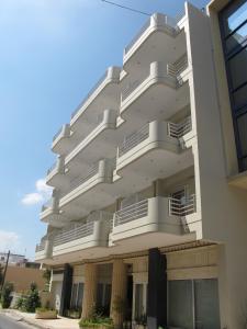 a large white building with balconies on it at Melissa II Hotel in Eleusis