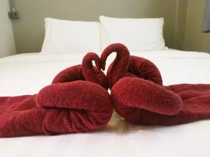 two towels shaped like swans sitting on a bed at Lotto House in Ko Samed