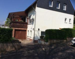 a white house with a wooden door and a balcony at Wenzel in Roxheim