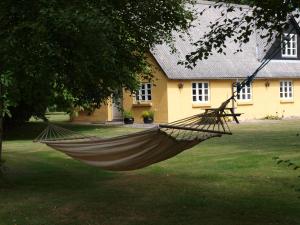 a hammock in a yard in front of a house at Fædrelandet Ferielejlighed & Turridning in Læsø +13 photos