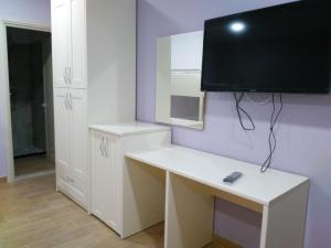 a white desk with a monitor on a purple wall at Aparthotel Fitimi in Borsh