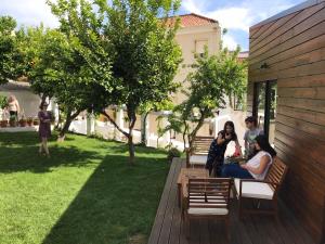 eine Gruppe von Menschen, die auf einer Bank auf einem Hof sitzen in der Unterkunft Casa do Muro in Coimbra