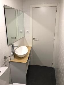 Un baño con un lavabo blanco y un espejo. en Casa do Muro, en Coímbra 18 fotos más