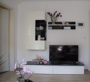 a living room with a large television on a white wall at Haase Eck in Bad Hönningen