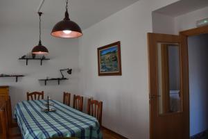 comedor con mesa y mantel azul y blanco en Apartamentos Picea Azul, en Vega de Espinareda