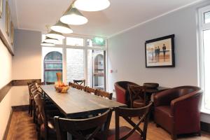 a dining room with a wooden table and chairs at Talbot Coach House in Dublin