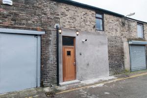 a brick building with a brown door on it at Talbot Coach House in Dublin