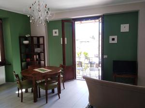 a dining room with green walls and a table and chairs at Nel cuore di Stresa by Stresahome - Centro storico in Stresa
