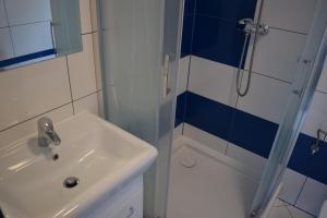 a bathroom with a sink and a shower at Willa Natenczas in Jarosławiec +20 photos