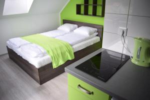 a small bedroom with a bed with a green wall at Willa Natenczas in Jarosławiec