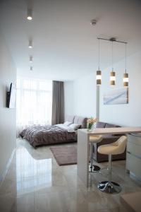 a living room with a desk and a bed at Sea Star Apartments (sea view) in Odesa
