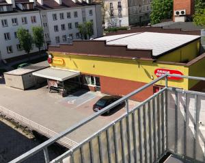 Un coche aparcado en un aparcamiento junto a un edificio. en Klimatyzowany Apartament Paris, en Kielce