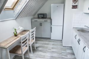 cocina con mesa de madera y nevera en Farmhouse Apartman en Eger