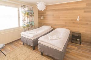 2 Einzelbetten in einem Zimmer mit Holzwänden in der Unterkunft Jääskän Loma Kojolapark, asunto 1, Alahärmä, Kauhava in Holma
