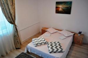 a bedroom with a bed with two pillows on it at Mariuca Apartament in Mangalia