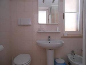 a bathroom with a sink and a toilet and a mirror at PENSIONE VERDE LUNA in Orbetello