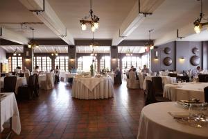 a banquet hall with white tables and people sitting at them at Active Hotel in Castione della Presolana