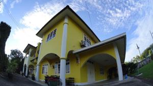 a yellow and white building with a sky at Homestay Petrajaya Kuching in Kuching