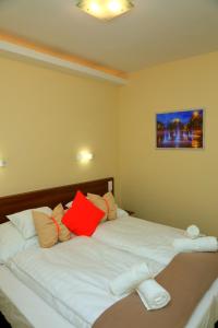 a bedroom with two beds with red and white pillows at Mária Apartman Pécs in Pécs