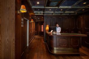 特拉维夫PLAY Seaport Suite Hotel TLV的坐在一张桌子上,手提电脑的房间里的人