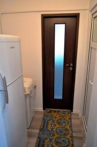 a door with a rug next to a refrigerator at Mariuca Apartament in Mangalia +9 photos