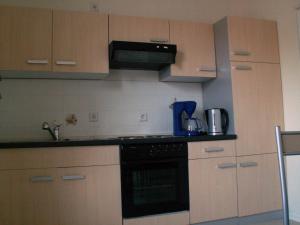 a kitchen with wooden cabinets and a black stove top oven at Ferienwohnung Köhler in Goslar
