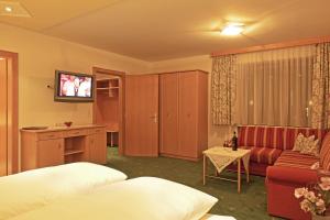 ザンクト・アントン・アム・アールベルクにあるHotel Angelikaのベッド2台とソファが備わるホテルルームです。