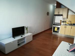 a living room with a flat screen tv on a white cabinet at El Charquito in Famara +6 photos