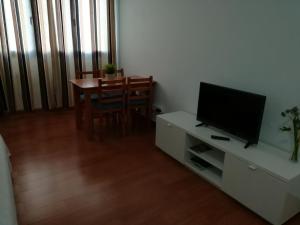 a living room with a television and a dining room table at El Charquito in Famara
