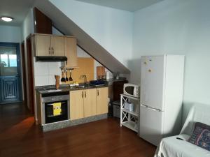 a small kitchen with a stove and a refrigerator at El Charquito in Famara