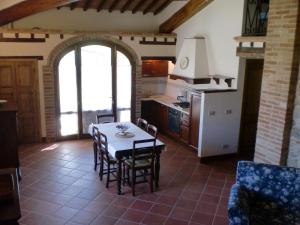 cocina y comedor con mesa y sillas en Agriturismo Fattoria Di Corsano, en Corsano