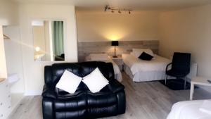 a hotel room with a bed and a leather couch at Wildwood Lodge in Carlingford