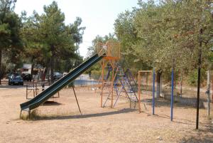 a playground with a slide in a park at Hotel Camping Agiannis in Makrygialos