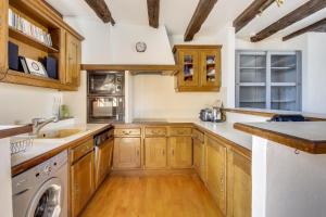 a kitchen with wooden cabinets and a washer and dryer at Le Corsaire de Solidor in Saint Malo +7 photos