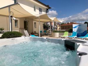 una piscina de agua con sillas en el patio trasero en Hotel Baia Bianca, en Diano Marina