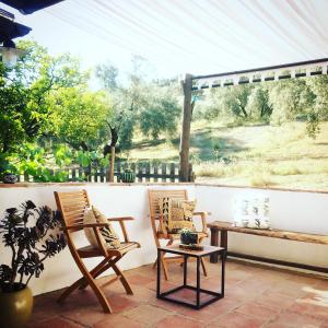 a patio with two chairs and a table and a window at Valle de Oro in Villanueva de Algaidas