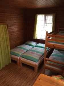 a bedroom with two bunk beds and a window at Chata Pod Bílým kamenem in Doksy