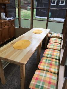 une table en bois avec un banc et des fenêtres dans l'établissement Chata Pod Bílým kamenem, à Doksy