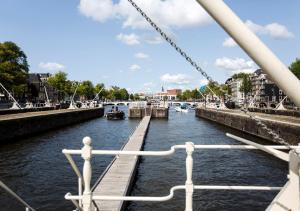 a boat is docked in a canal at SWEETS - Amstelschutsluis in Amsterdam