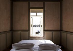 a bed with two pillows in a room with a window at SWEETS - Amstelschutsluis in Amsterdam