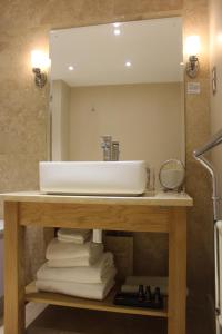 uma casa de banho com lavatório, espelho e toalhas em Mallyan Spout Hotel em Goathland