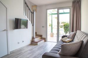 a living room with a couch and a tv at Complejo Sun's Gardens - Maspalomas in Maspalomas