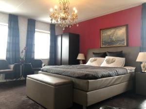 a bedroom with red walls and a bed with a chandelier at B&B nancy in holland in Aalten