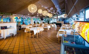 un restaurant avec des tables et des chaises blanches et un jeu dans l'établissement Hvide Sande Beach Apartments, à Hvide Sande