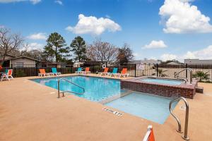 a large swimming pool with chairs at Comfort Inn & Suites and Suites Fredericksburg in Fredericksburg