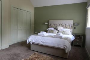 1 dormitorio con 1 cama con sábanas y almohadas blancas en The Sheiling, en Dornie